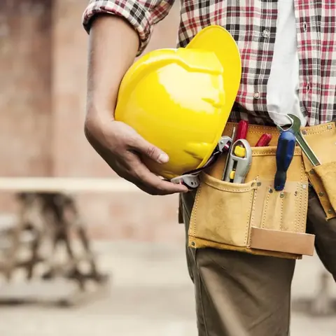 Installer holding a hard hat and tools during professional training