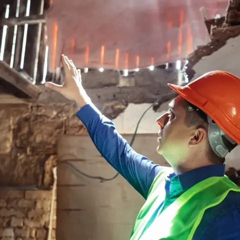 Retrofit surveyor inspecting the structure of a traditional building